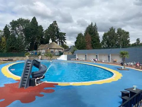 una piscina con una silla en el centro en Lakeside Escape Modern 2 Bedroom Holiday Home en Overstone