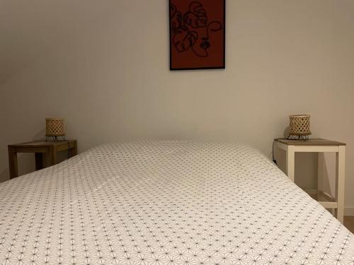 1 Schlafzimmer mit einem weißen Bett und 2 Tischen in der Unterkunft Bel appartement 2 chambres 