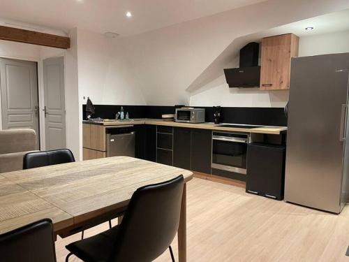 a kitchen with a wooden table and a kitchen with a table and chairs at Bel appartement 2 chambres in Ham