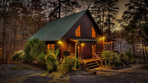 a cabin in the woods at night with lights at Lake Escape in Morganton