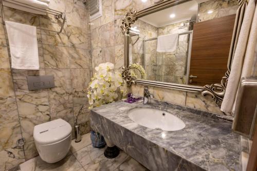 a bathroom with a sink and a toilet and a mirror at Anatolia Hotel Airport in Trabzon
