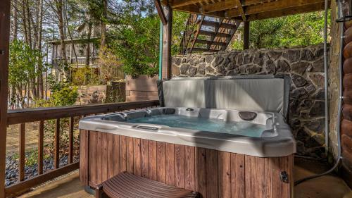 a hot tub on a balcony with a stone wall at Lake Escape in Morganton