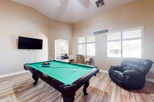 a living room with a pool table and a chair at The Beach House in Surprise