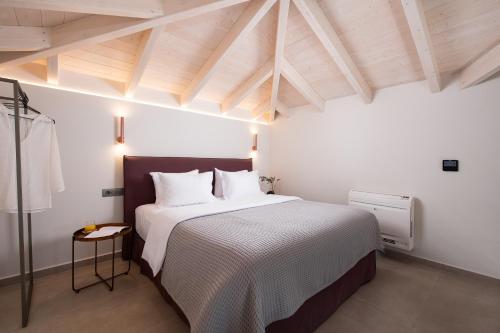 a bedroom with a large bed with a wooden ceiling at Reveli Suites in Katelios