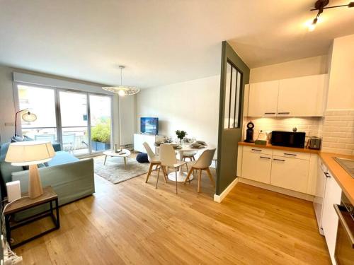 une cuisine et un salon avec une table et des chaises dans l'établissement Le Familial - Terrasse - Proximité Genève, à Saint-Genis-Pouilly