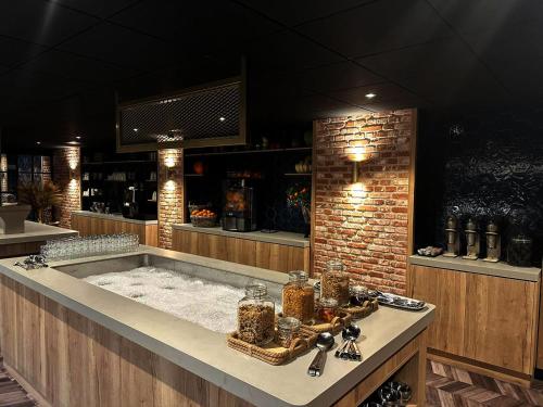 una vasca da bagno in un bar con muro di mattoni di Hotel de Naaldhof a Oss