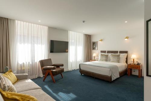 a hotel room with a bed and a couch at Westlight Lisboa Madalena in Lisbon