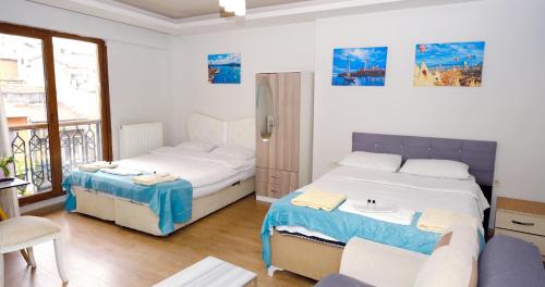 Taksim Next Hotel في إسطنبول: غرفة نوم بسريرين واريكة فيها