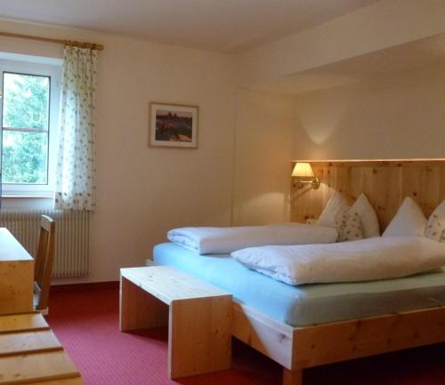 a hotel room with two beds and a window at LAKE & RIVER Hotel in Carezza al Lago