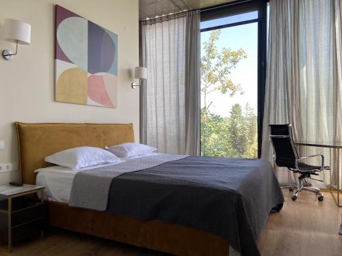 1 dormitorio con 1 cama, 1 silla y 1 ventana en Villa 6 Ambassadori Kachreti Golf Resort en Kachretʼi