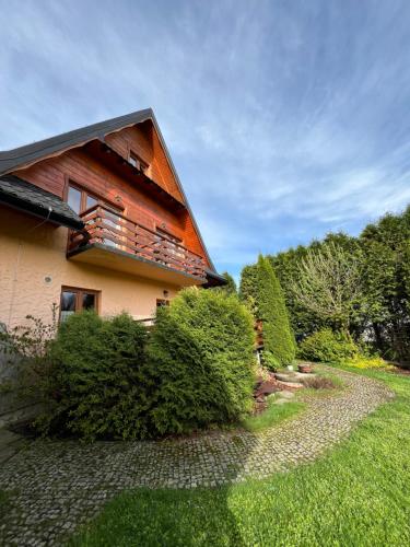 a house with a gambrel roof on the side of it at POD ROŻKAMI in Cisna