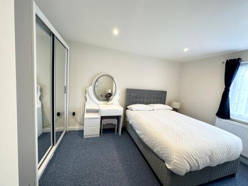 um quarto com uma cama com um espelho e um toucador em 3 Bedroom Home In London - Lee - By Atleys Homes em Londres