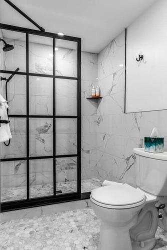 a bathroom with a toilet and a glass shower door at DTWN Bangor, Historic Hotel, KING BED, WIFI, Roku TV, Room # 403 in Bangor