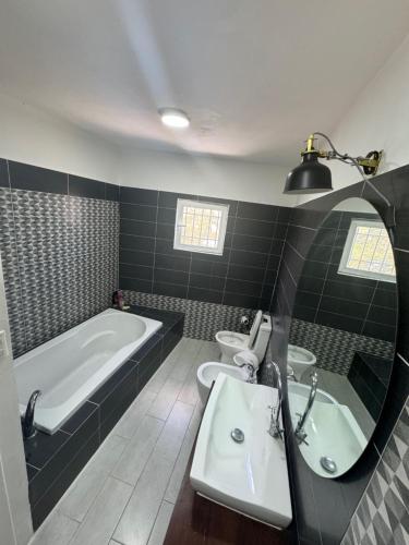 a bathroom with a tub and two sinks and a bath tub at El Conde De Atrini in Santo Domingo