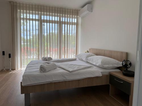 a bed in a bedroom with a large window at Dea sobe in Posušje