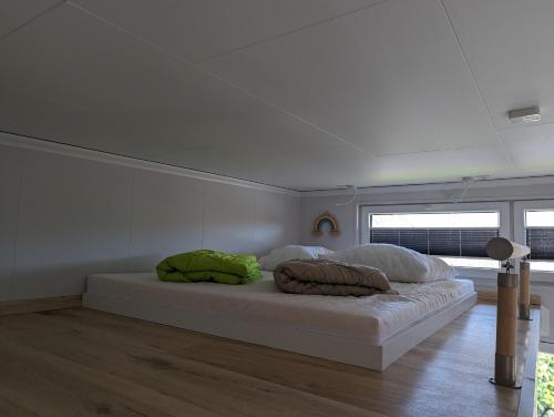 a bed with two pillows on it in a room at Tiny House Daniel in Papenburg