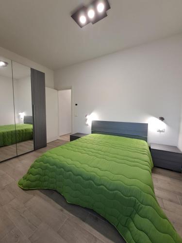 een slaapkamer met een groen dekbed op een bed bij Casa Tizy in Botrugno