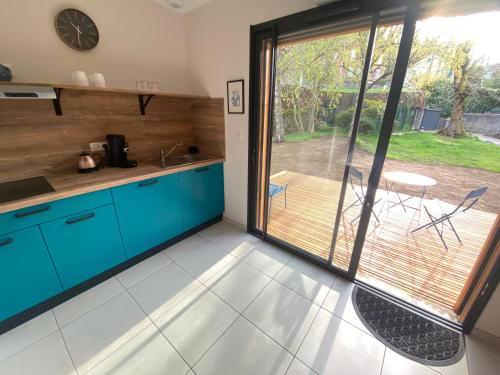 a kitchen with blue cabinets and a sliding glass door at L'Oustal Des Dômes in Orcines