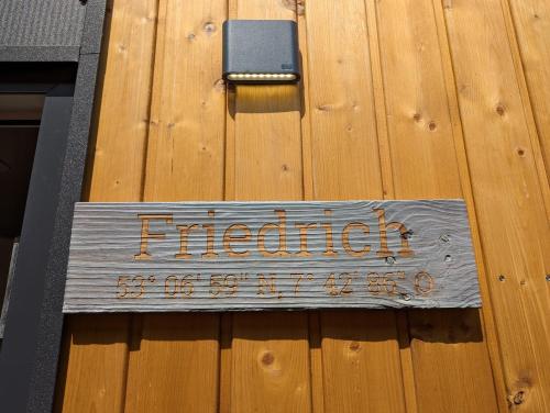 a sign on the side of a wooden door at Hausboot Friedrich in Papenburg