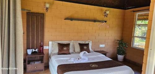 a bedroom with a bed with a swan on it at Bhuvi Wayanad Natural Tea Plantation Resort in Wayanad