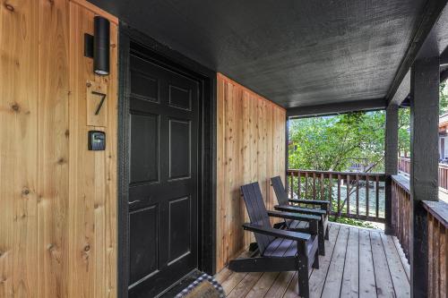 two chairs sitting on a porch with a black door at Shasta View Lodge in McCloud