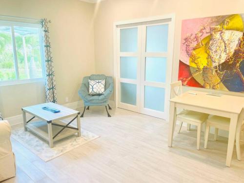 a living room with a table and a chair at Delightful Cottage - 30 Secs Walk to the Beach in Nassau