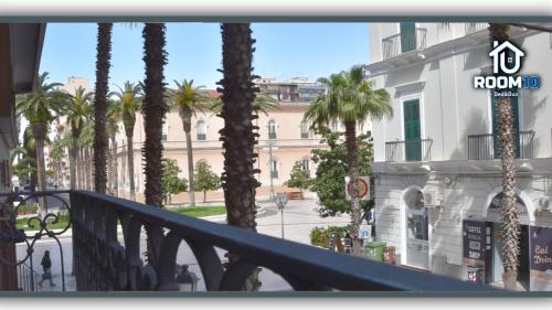 a balcony with palm trees in front of a building at Room 10 in Taranto