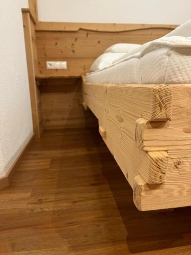 a bed in a room with a wooden floor at Apart Alpenpension Maderer in Gaschurn