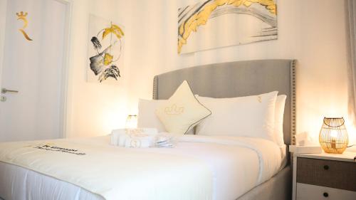 a bedroom with a bed with white sheets and pillows at Luxury 2BR Duplex Oasis in Masdar City - Stylish Retreat Near Masdar Park & City Centre in Abu Dhabi