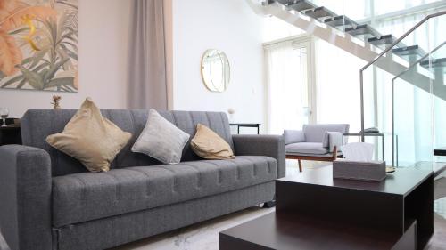 a living room with a couch and a table at Luxury 2BR Duplex Oasis in Masdar City - Stylish Retreat Near Masdar Park & City Centre in Abu Dhabi