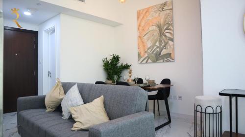 a living room with a couch and a table at Luxury 2BR Duplex Oasis in Masdar City - Stylish Retreat Near Masdar Park & City Centre in Abu Dhabi