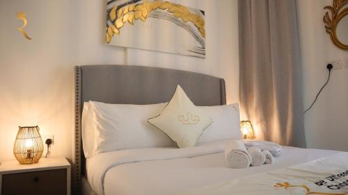 a bedroom with a bed with two towels on it at Luxury Duplex 2BR Oasis. in Abu Dhabi