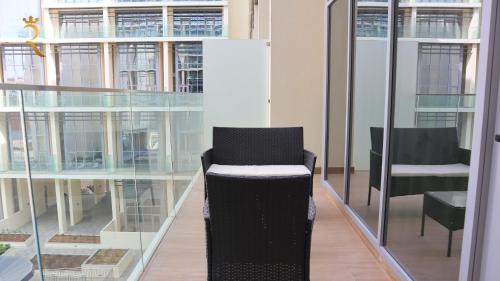 a black chair in a room with glass windows at Luxury 2BR Duplex Oasis in Masdar City - Stylish Retreat Near Masdar Park & City Centre in Abu Dhabi