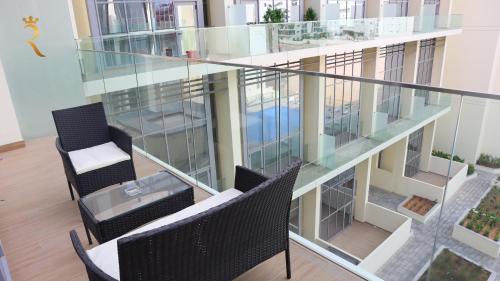 a glass balcony with two chairs and a table at Luxury 2BR Duplex Oasis in Masdar City - Stylish Retreat Near Masdar Park & City Centre in Abu Dhabi