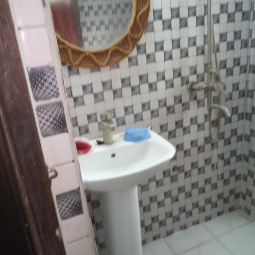W łazience znajduje się umywalka i lustro. w obiekcie Together forever w mieście Ngambo