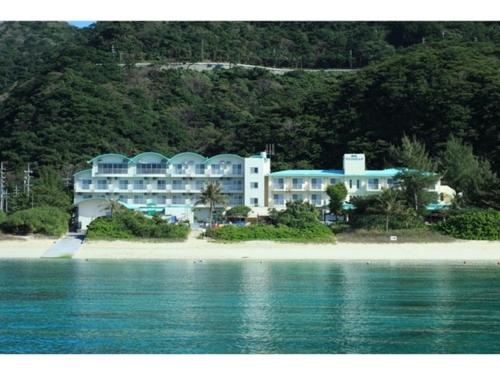 Tokashiku的住宿－Tokashiku Marine Village - Vacation STAY 18559v，毗邻水面的海滩上的一家大型酒店