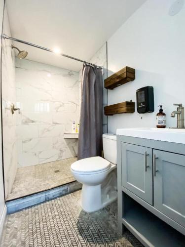 a bathroom with a toilet and a shower and a sink at Rumi in Los Angeles