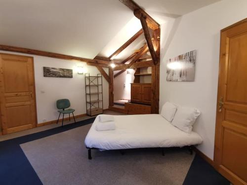 ein Schlafzimmer mit einem weißen Bett in einem Zimmer in der Unterkunft Duplex with garden Mountain view in Les Houches