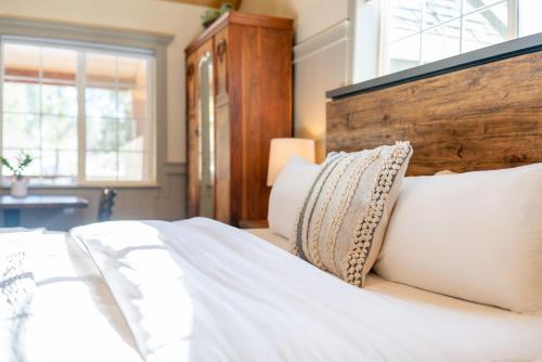 a bedroom with a bed with white sheets and pillows at Shasta View Lodge in McCloud