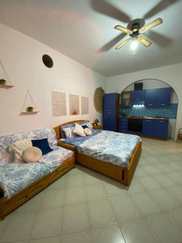 a bedroom with two beds and a ceiling fan at Villa Katy in Panarea