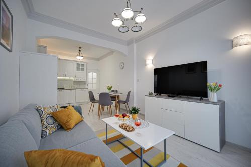 Una sala de estar con un sofá, un televisor y una mesa. en Tulip Dreamland, en Sofía