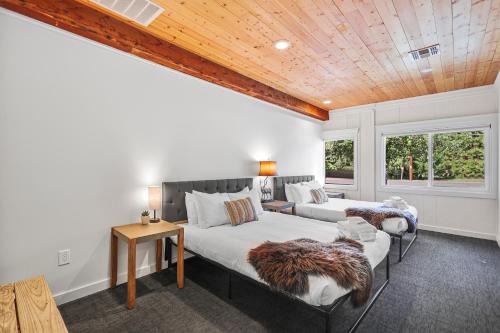 a bedroom with two beds and a wooden ceiling at Shasta View Lodge in McCloud