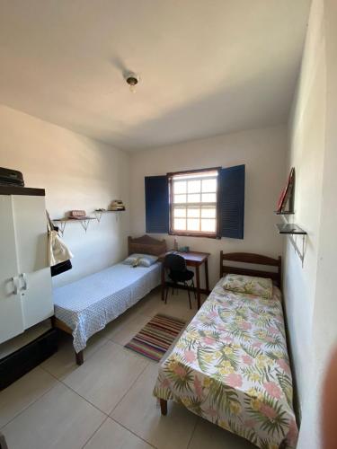 a bedroom with two beds and a desk and a window at República Xamego in Ouro Preto