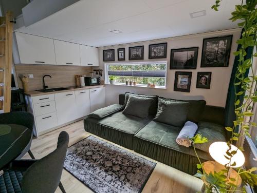 uma sala de estar com um sofá e uma cozinha em Tiny House Nelson em Papenburg