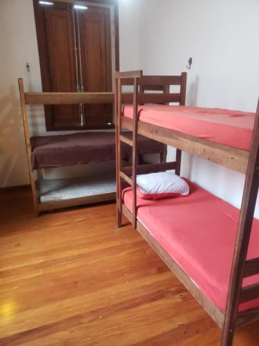 a room with two bunk beds and a wooden floor at Rolls Hostel in Rio de Janeiro