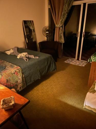 Schlafzimmer mit einem Bett, einem Fenster und einem Tisch in der Unterkunft ROOM LE BASSIN in Tiarei
