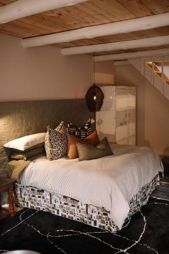 a bedroom with a large bed with pillows on it at Rest Guesthouse in Dullstroom