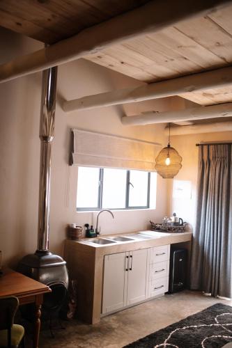 a kitchen with a stove and a sink in a room at Rest Guesthouse in Dullstroom