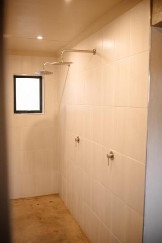a bathroom with white tile walls and a window at Rest Guesthouse in Dullstroom