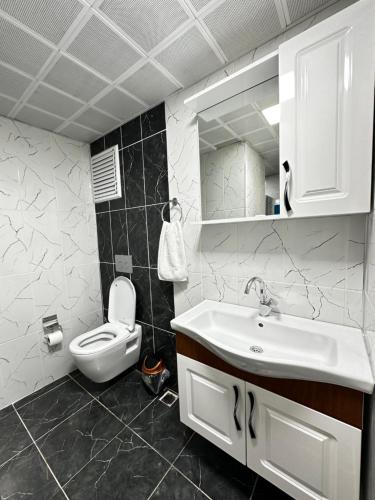 een badkamer met een witte wastafel en een toilet bij Renaissance Apart Hotel in Trabzon